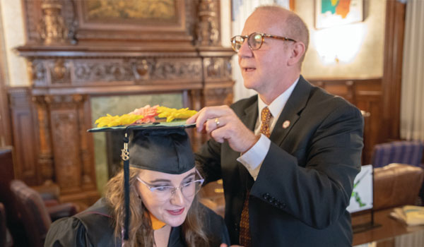 Samantha and her father, Keith, prepare for her Commencement Ceremony in May.
