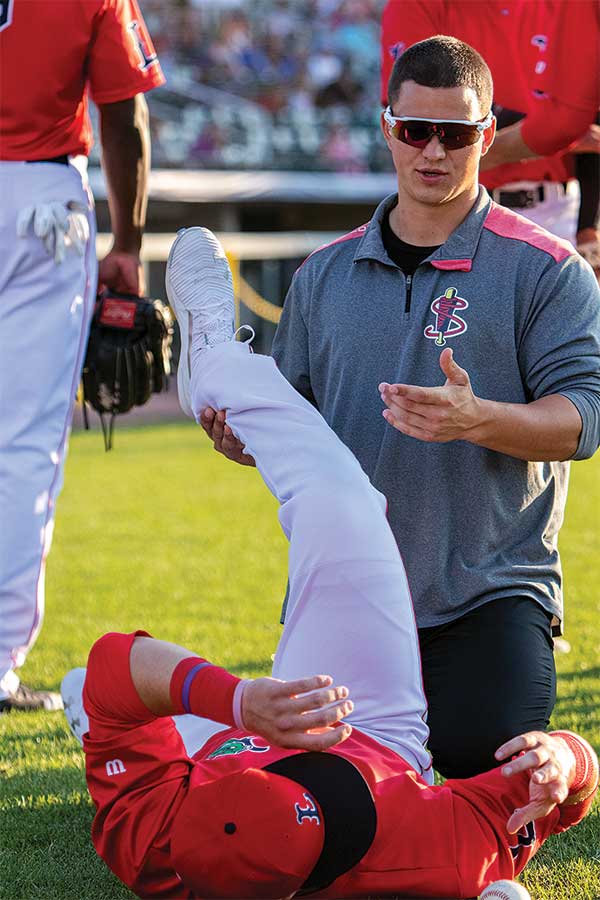  Colin Feikles helps Nick Decker of the Lowell Spinners
