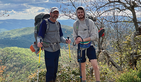 Wesley Wohlford and his father stand atop a mountain while hiking the Appalachian Trail.